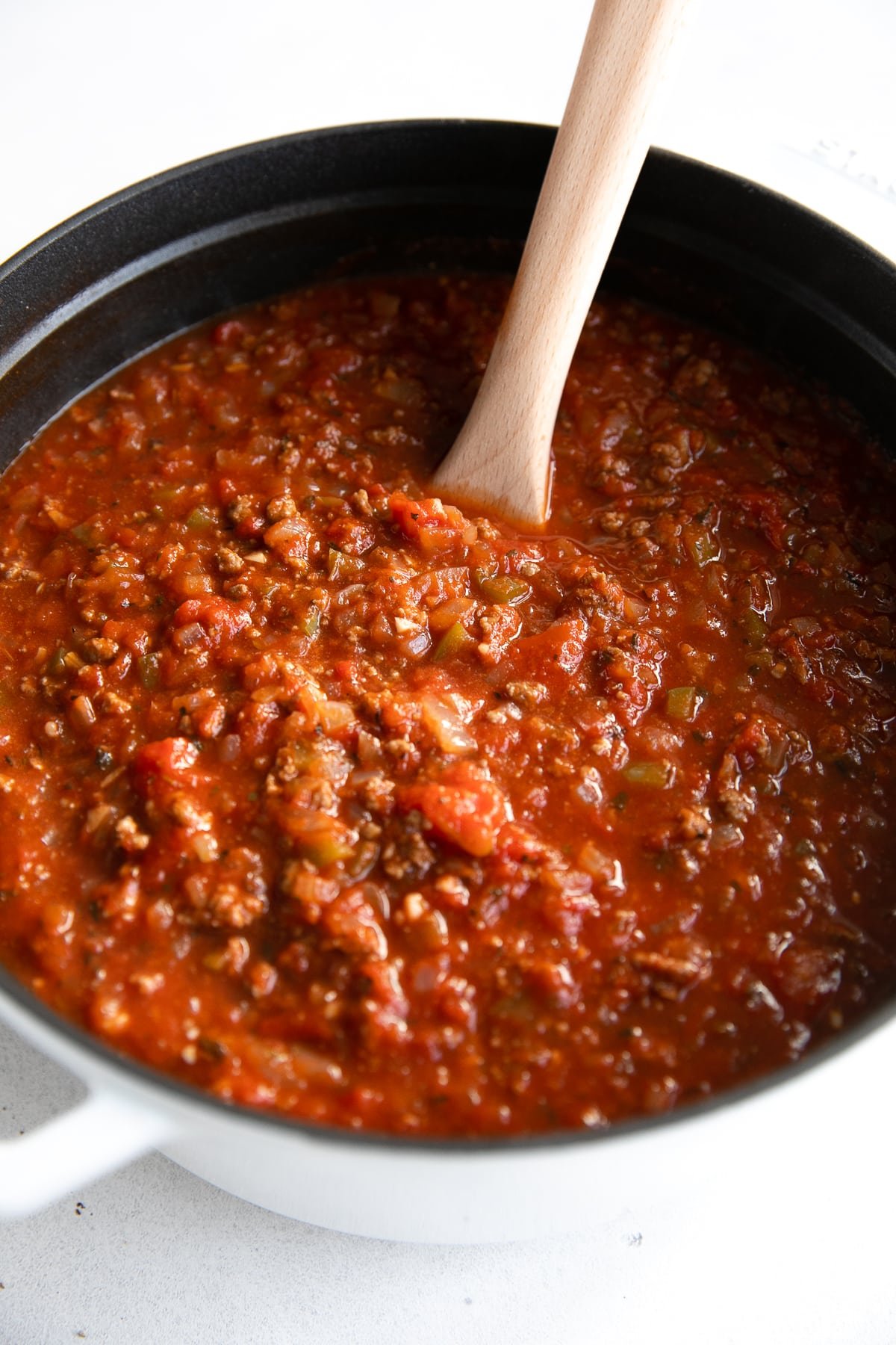 Large heavy-bottom pot filled with the best spaghetti sauce made with onion, garlic, tomato paste, tomatoes, and ground beef.