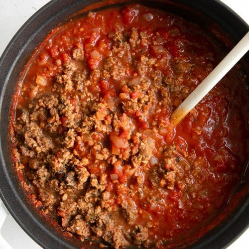 Overhead image of a pot filled with plant based ground meat mixed with homemade tomato sauce.