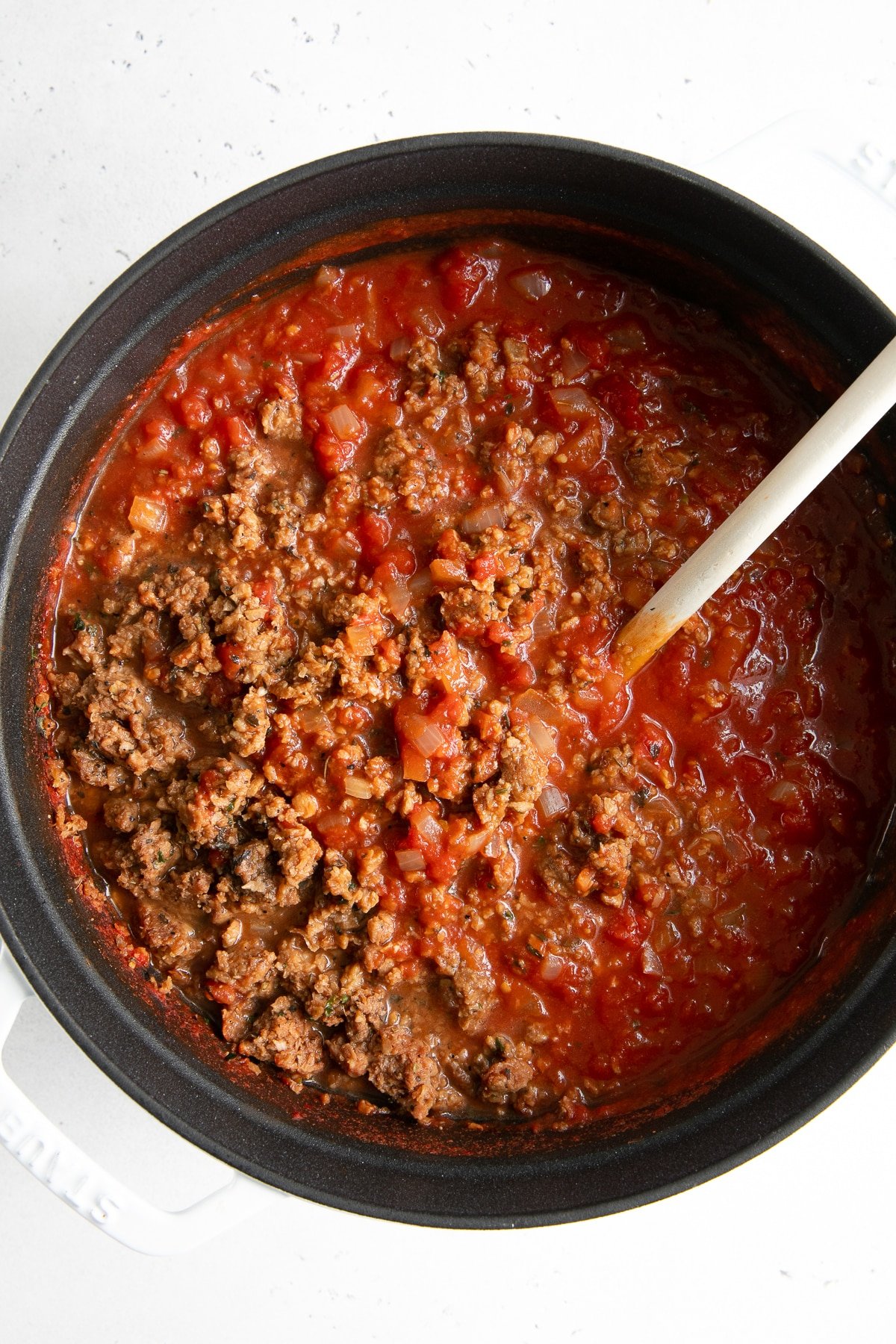 Overhead image of a pot filled with plant based ground meat mixed with homemade tomato sauce.