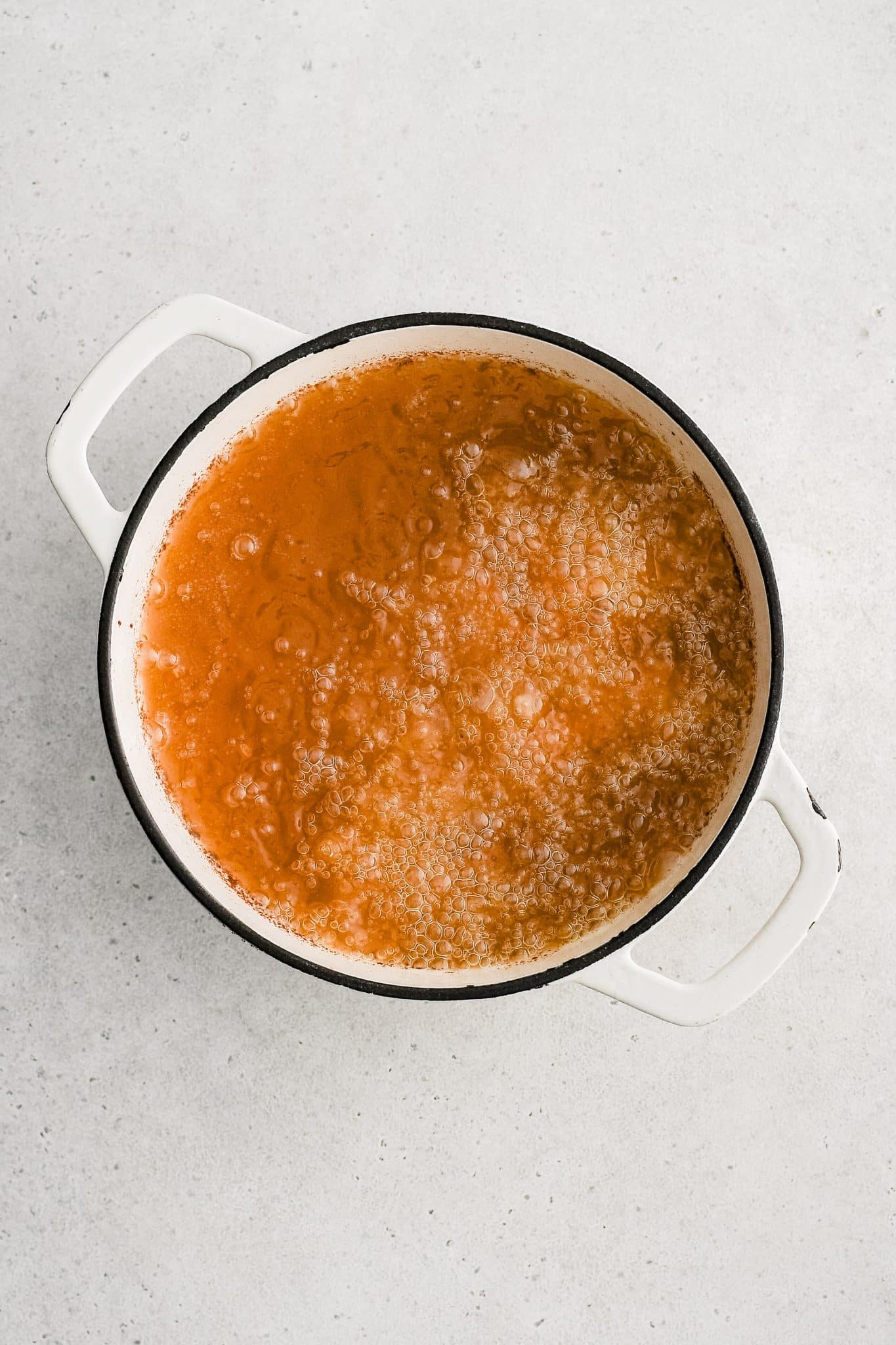 Large Dutch oven with breaded chicken drumstick added to hot oil.