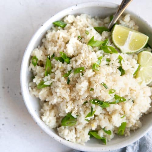 White bowl filled with cooked and fluffy coconut rice.