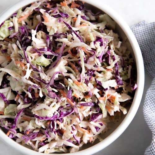 Creamy classic coleslaw in a large white bowl.