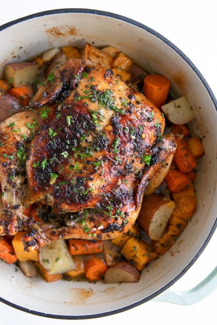 Large Dutch oven filled with a garlic and butter herb roasted chicken.