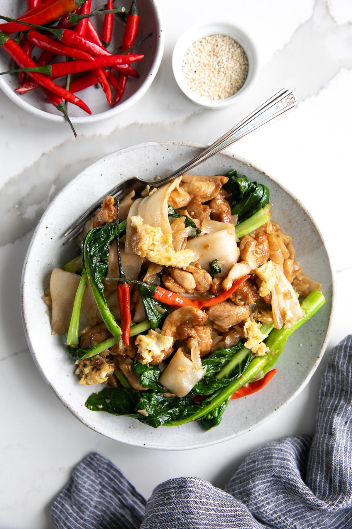 A plate of pad see ew (Phat si-io) made with chicken and chinese broccoli.