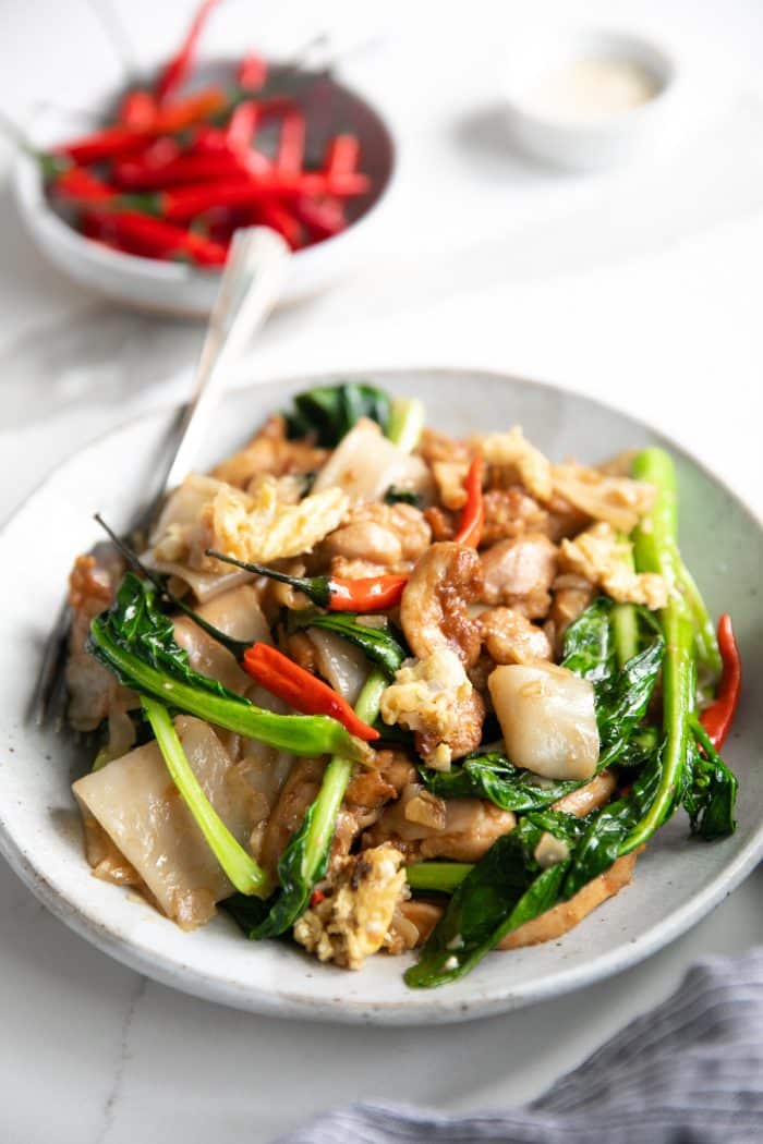 A plate of pad see ew (Phat si-io) made with chicken and chinese broccoli.