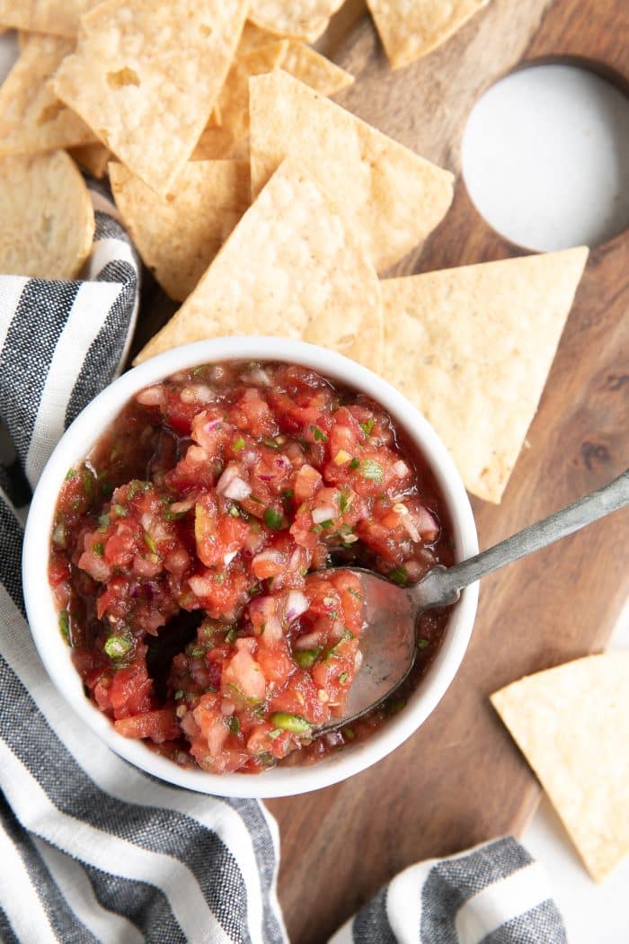 Ramekin filled with salsa and served with tortilla chips.