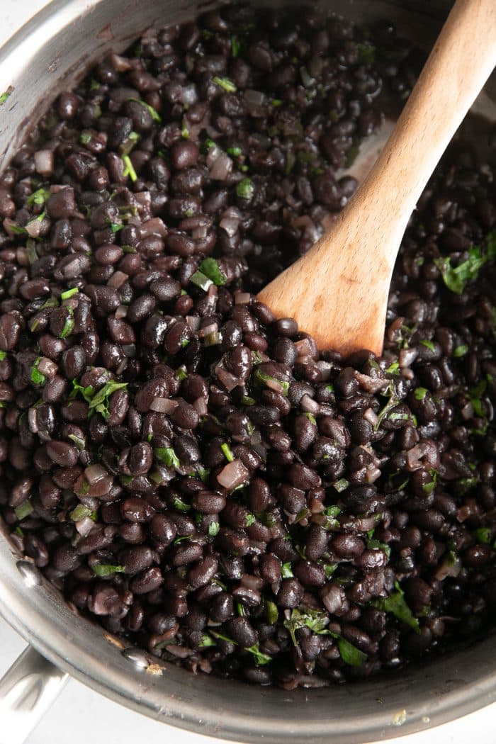 Image of Mexican-style black beans simmering in a medium pan.