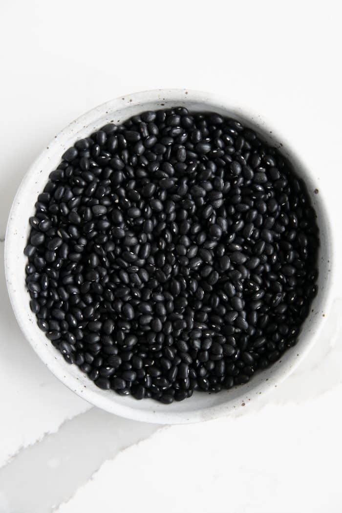 Bowl filled with dry black beans.