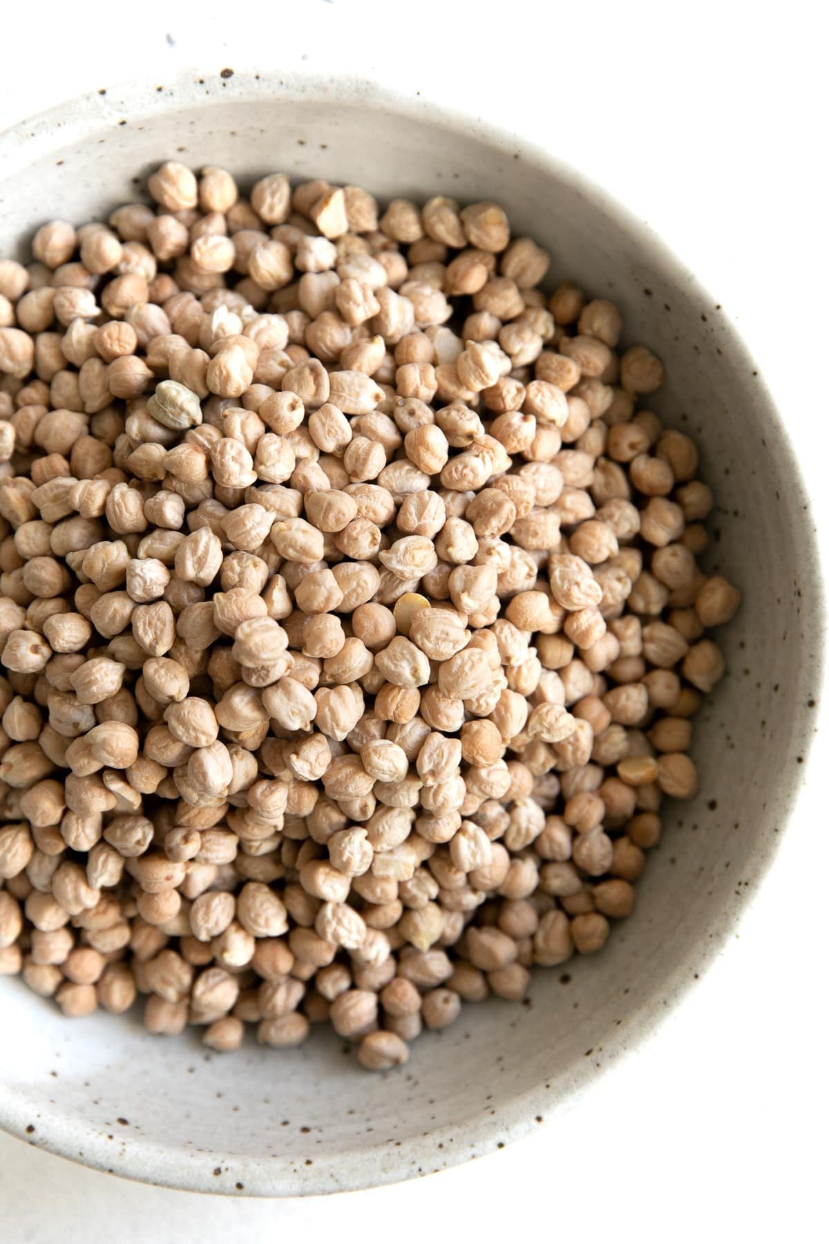 Large shallow bowl filled with dry chickpeas.