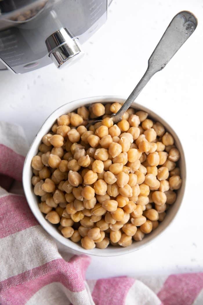 White bowl filled with cooked garbanzo beans.