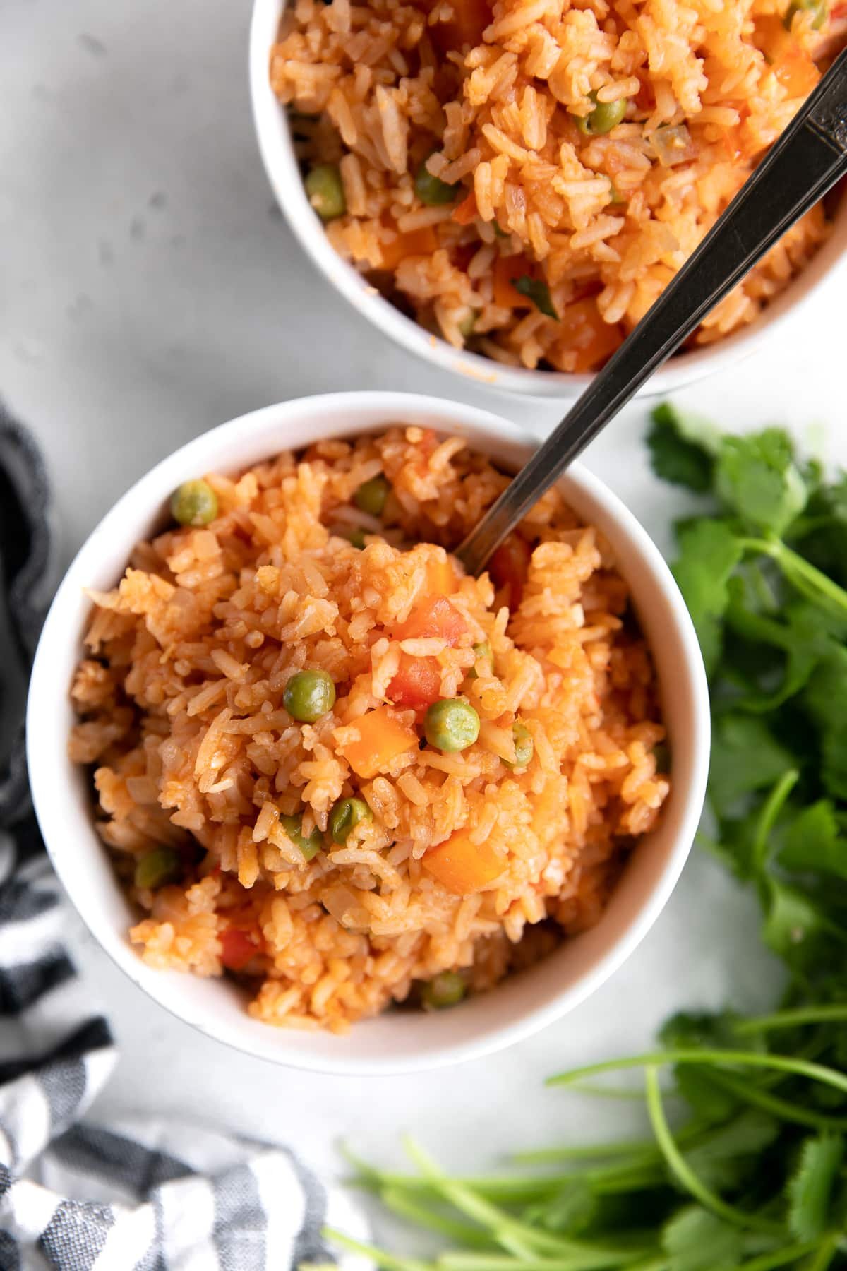 Small white serving bowls filled with Mexican style rice.