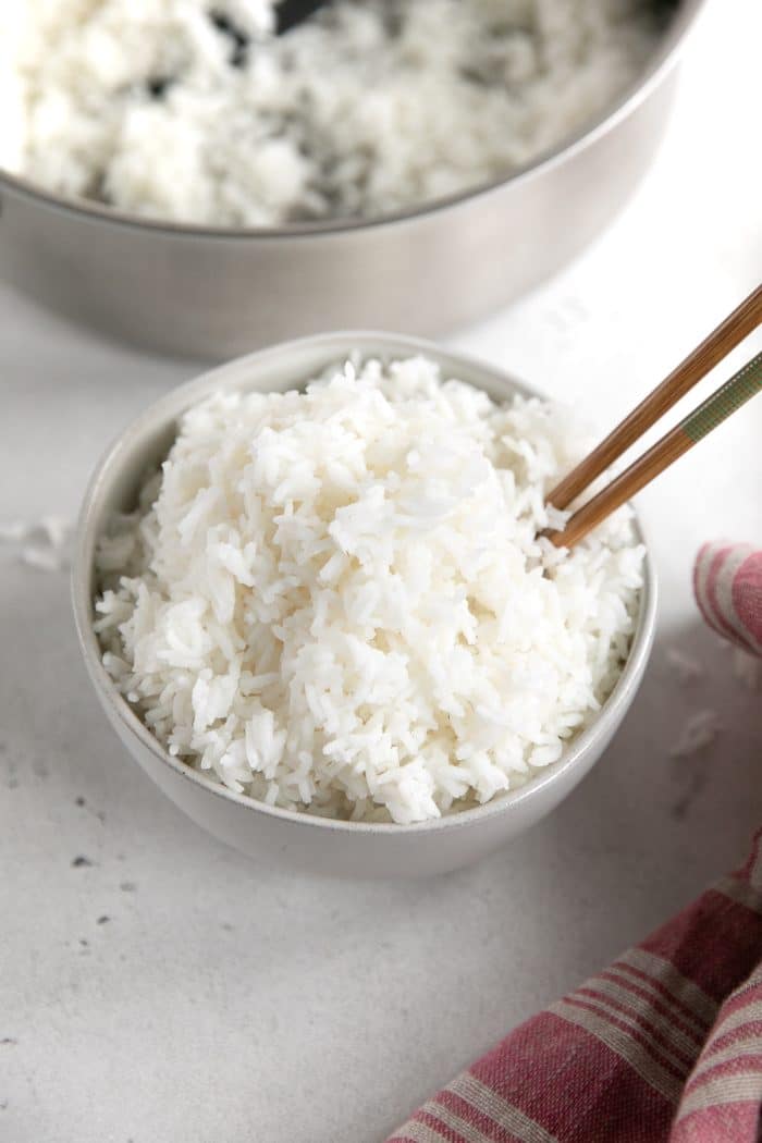 White serving bowl filled with cooked white rice made of the stovetop.