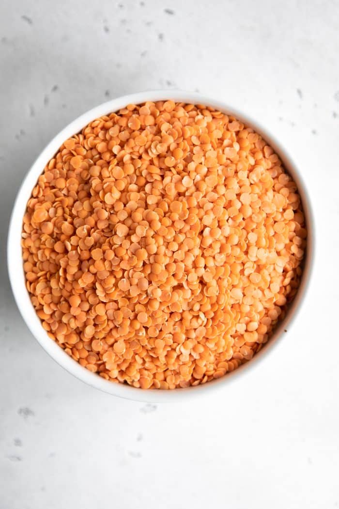 Red lentils in a white bowl.