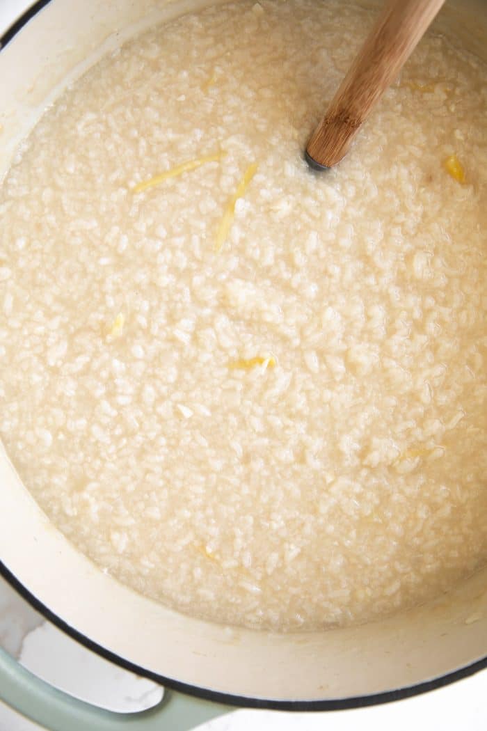 Large pot filled with cooked Filipino rice porridge, or pospas, seasoned with garlic and ginger. 