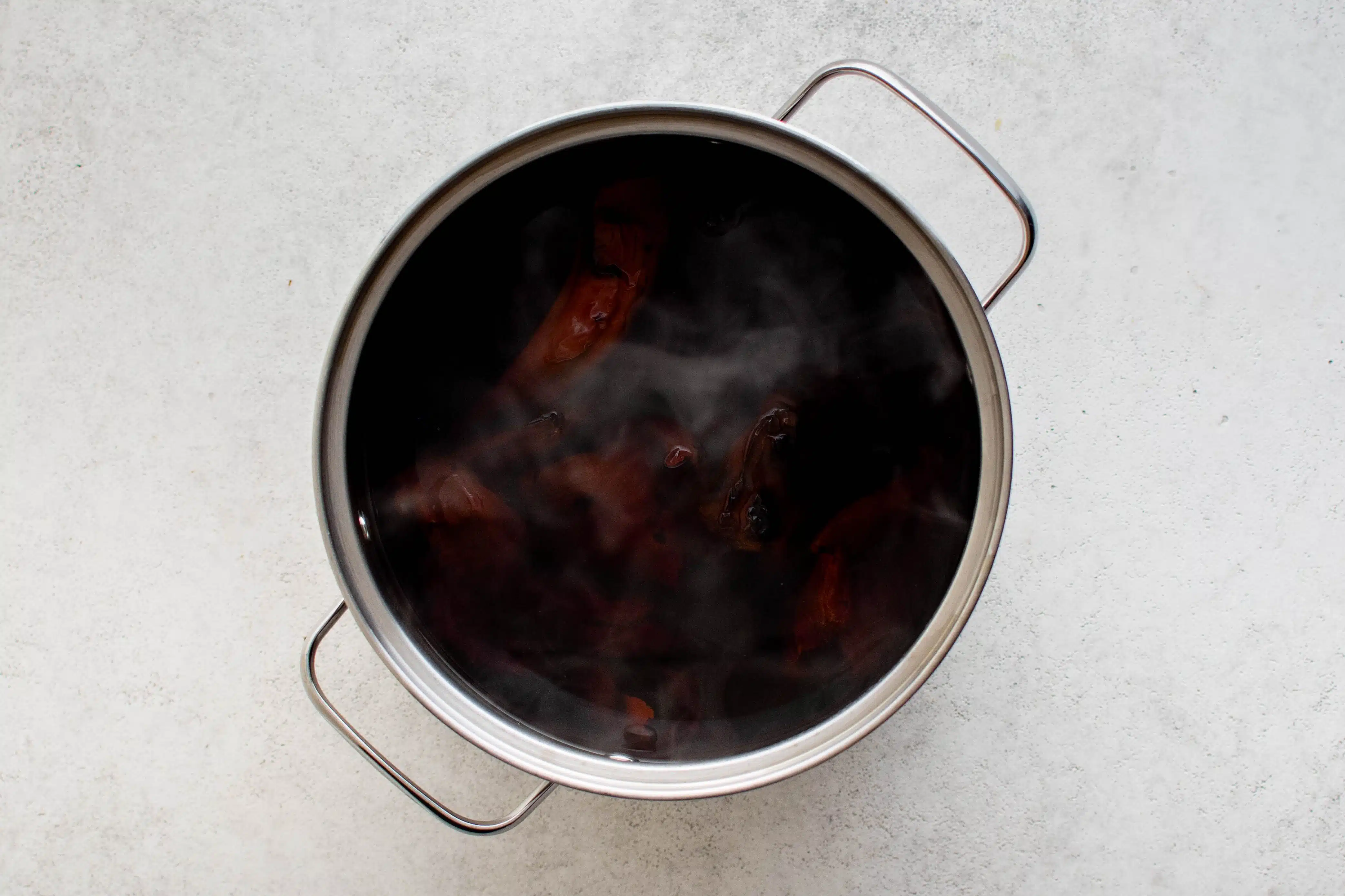 Pot filled with dried chiles covered in boiling water.