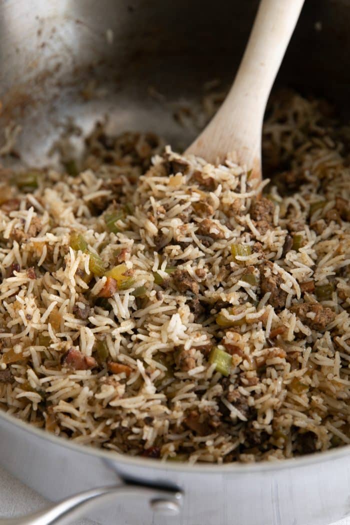 Fully cooked Cajun dirty rice recipe in a large heavy-bottomed pot ready to be served.