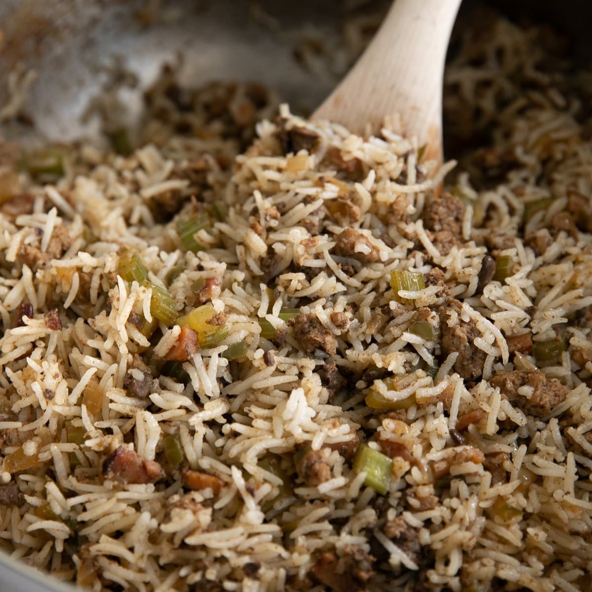 Fully cooked Cajun dirty rice recipe in a large heavy-bottomed pot ready to be served.