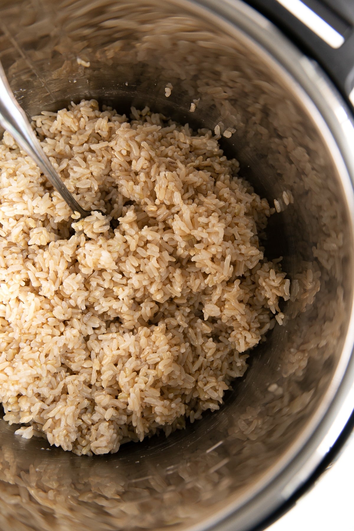 Looking into the bowl of an Instant Pot filled with cooked brown rice.