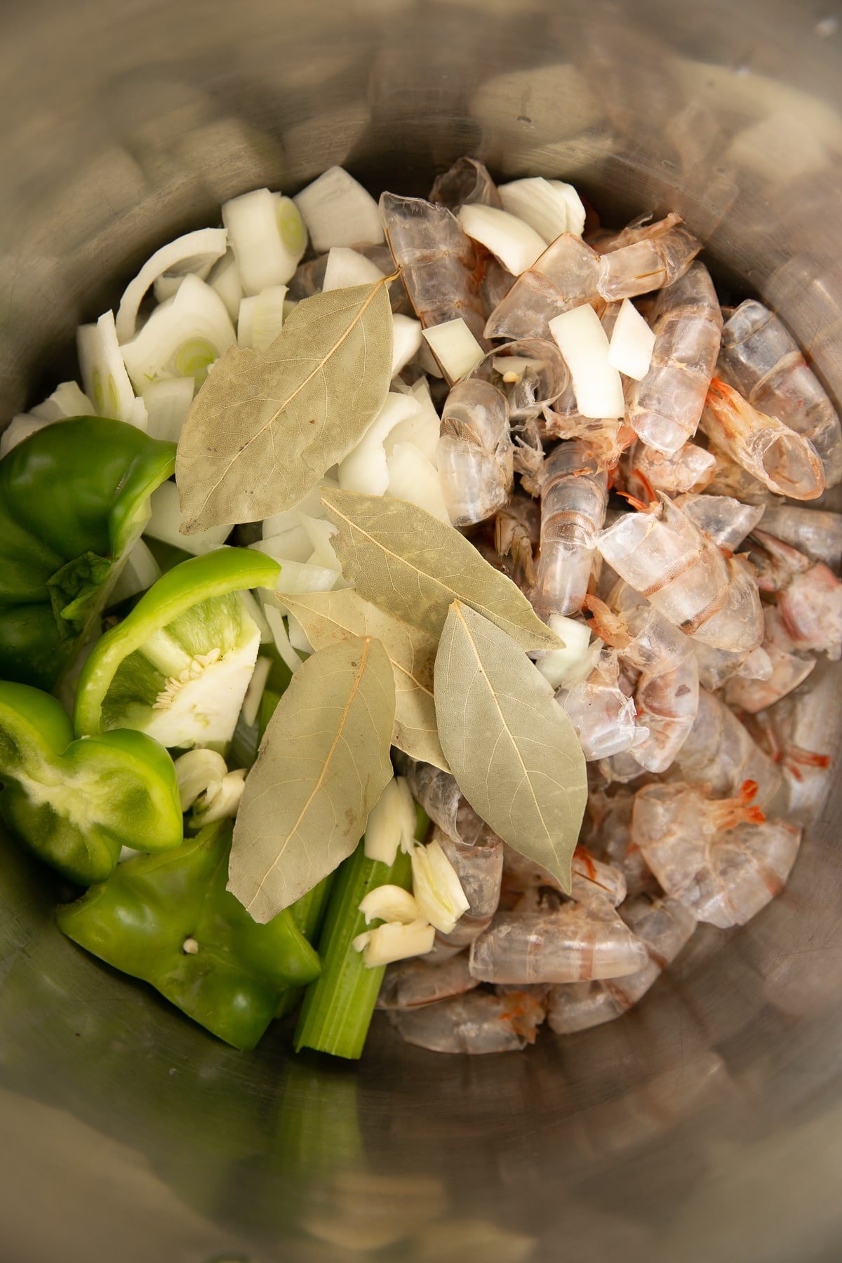 Preparing homemade shrimp stock from the discarded shrimp tails, bay leaves, onion, and bell pepper.