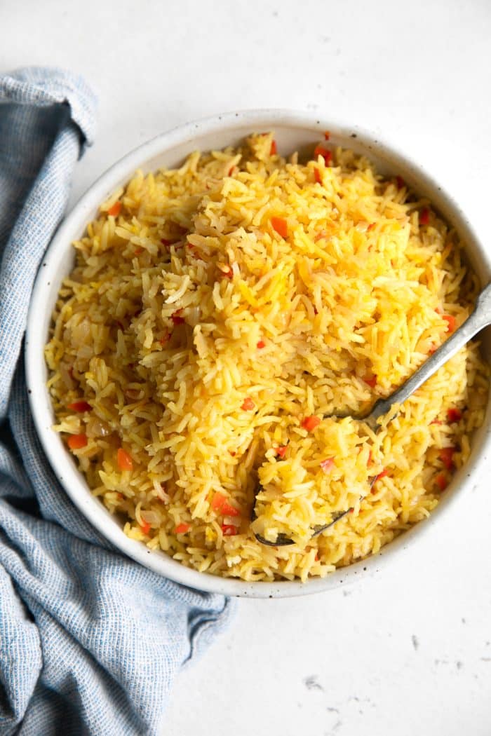 Overhead view of a large bowl filled with yellow, fluffy Spanish rice.