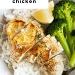 Baked lemon chicken breast sliced on a plate with rice and broccoli.