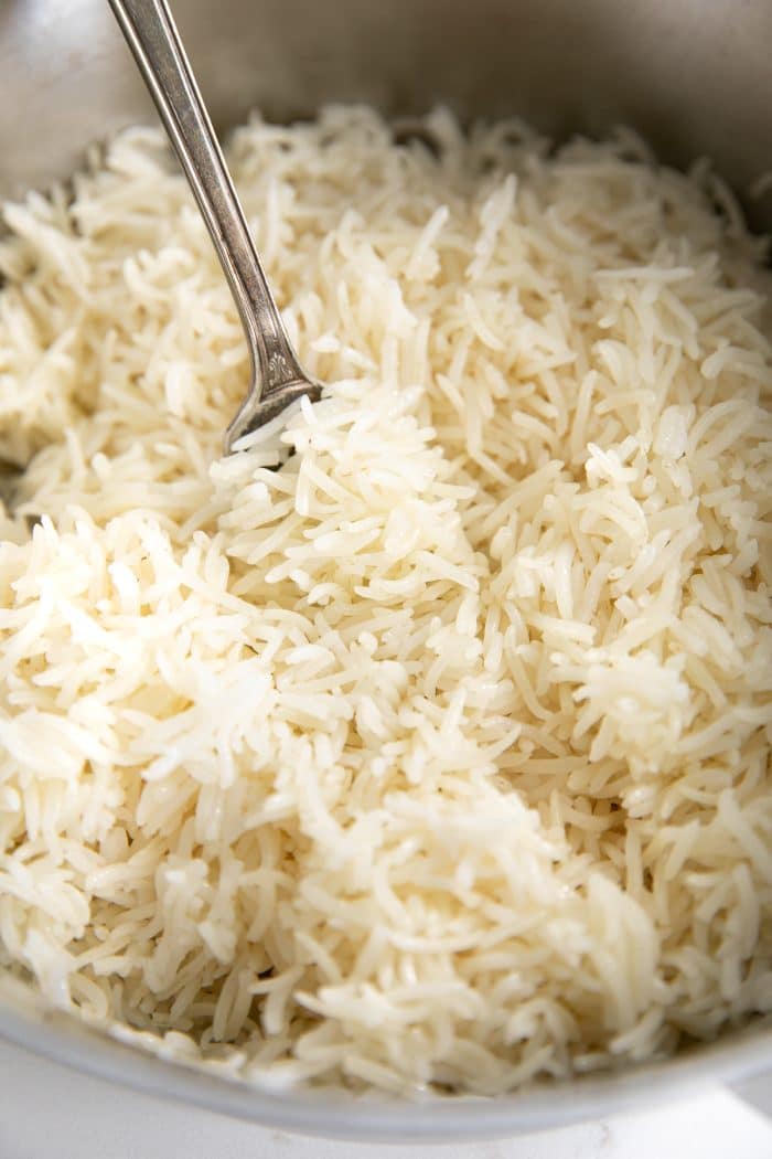 Perfectly cooked tender grains of white basmati rice in a medium pot.