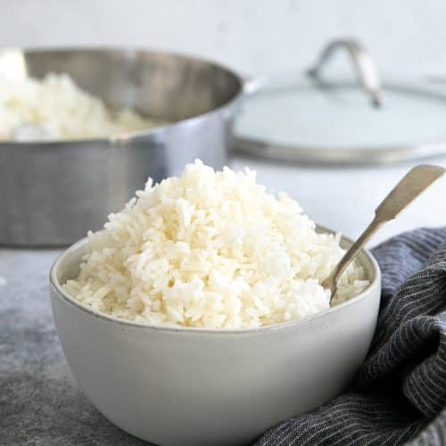 White bowl filled with cooked jasmine rice.