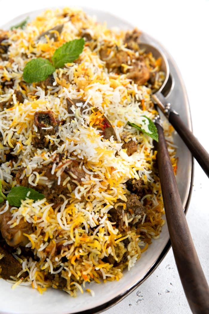 Large platter filled with cooked lamb and chicken biryani recipe.