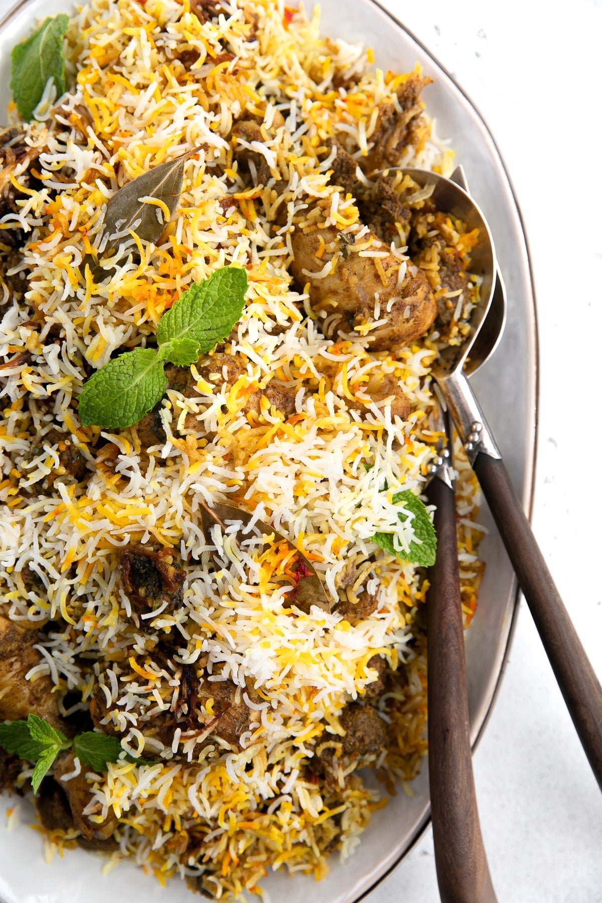 Large platter filled with cooked lamb and chicken biryani recipe.