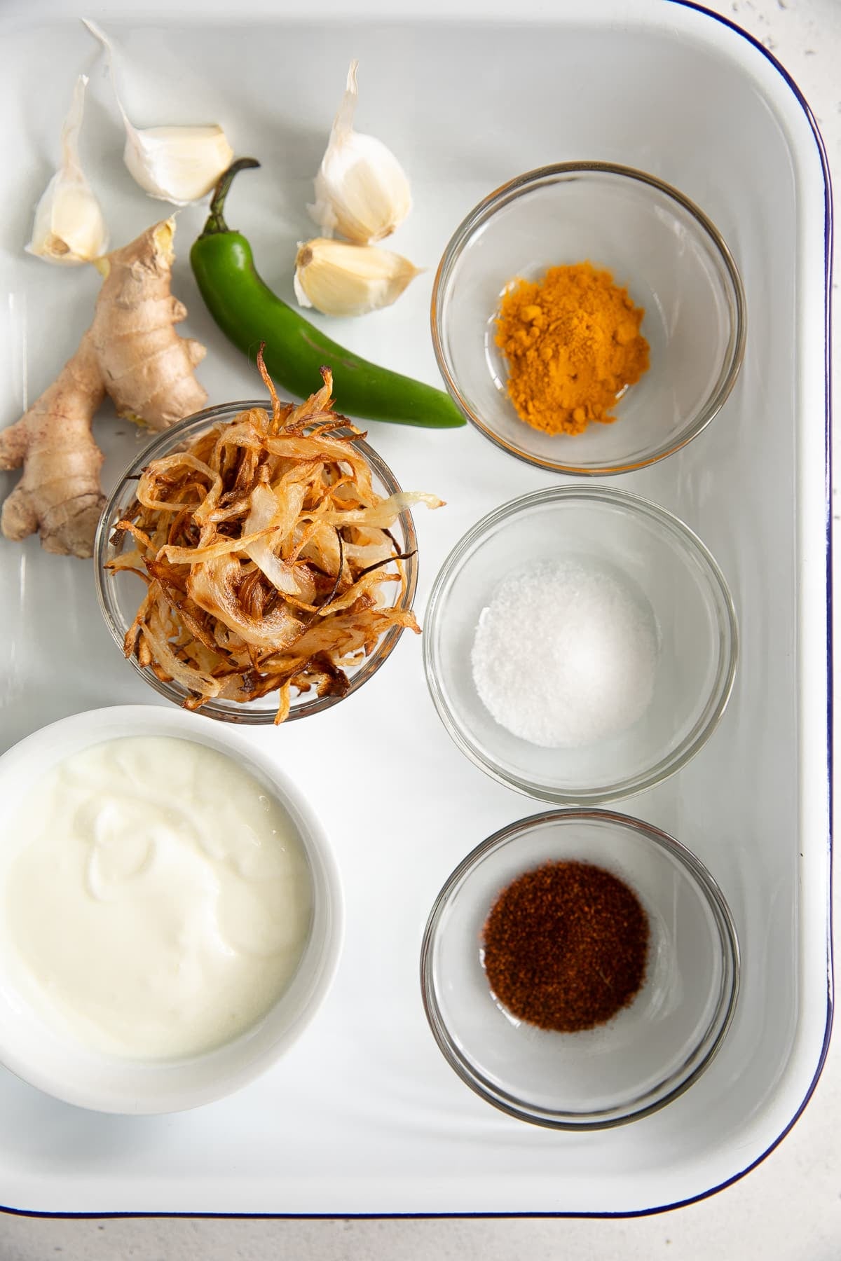 A plater of Biryani ingredients including onions, ginger, chili