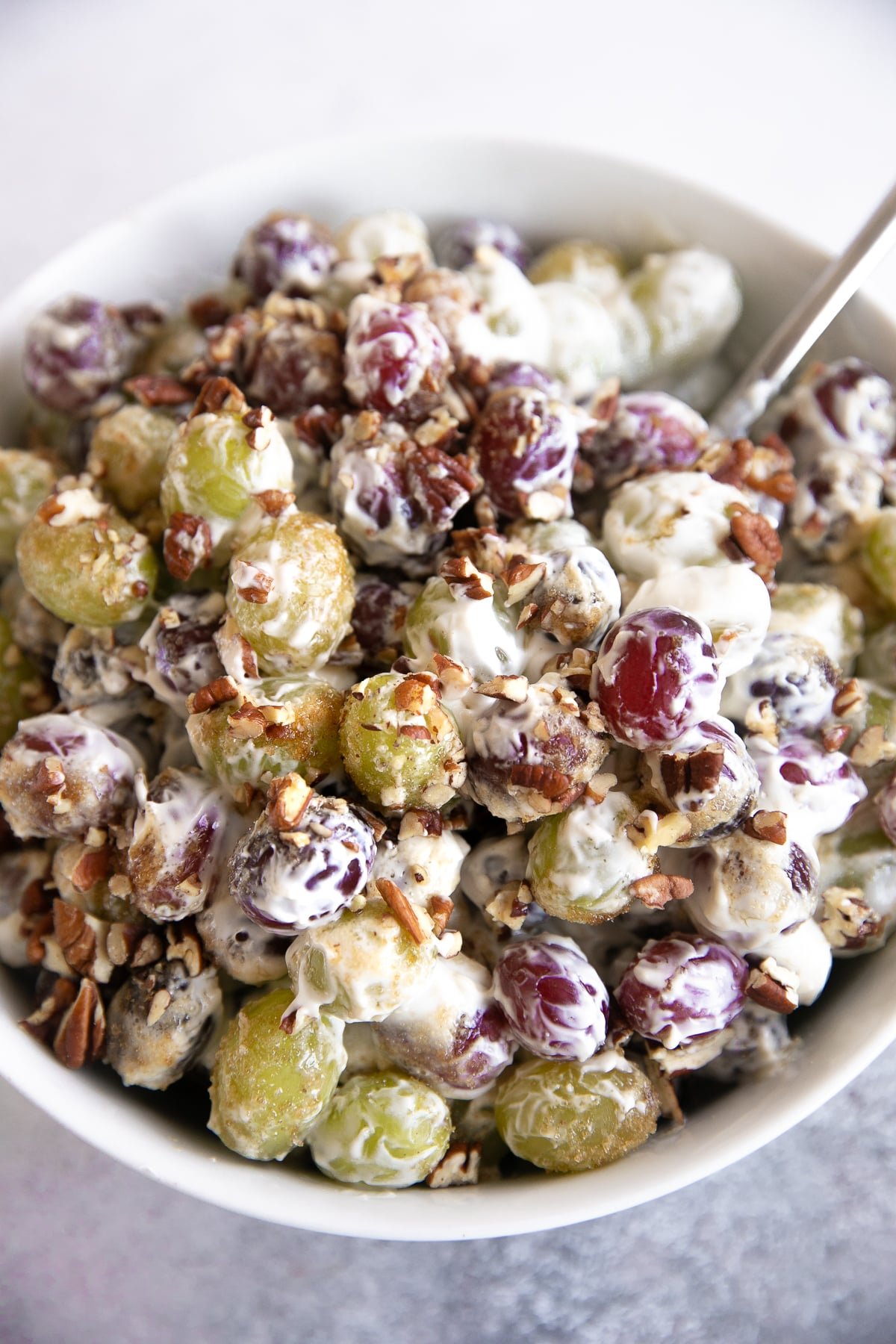 Creamy grape salad tossed with nuts and sprinkled with brown sugar.