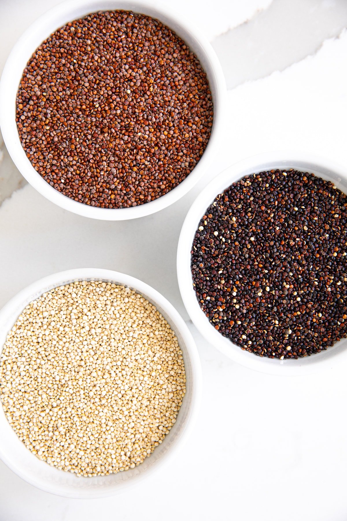 Bowls filled with red, black, and white quinoa.