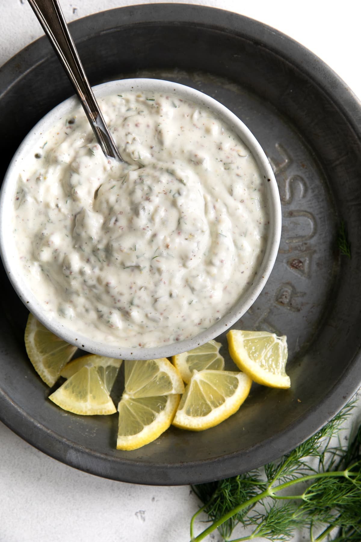 Tartar sauce in a small white serving dish on an aluminum pan.
