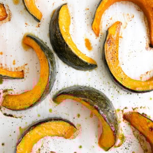 Tender roasted wedges of kabocha squash on a large baking sheet.