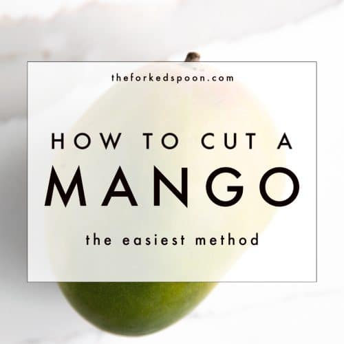 Whole mango on a marble cutting board with text overlay