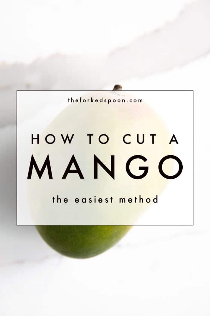 Whole mango on a marble cutting board with text overlay