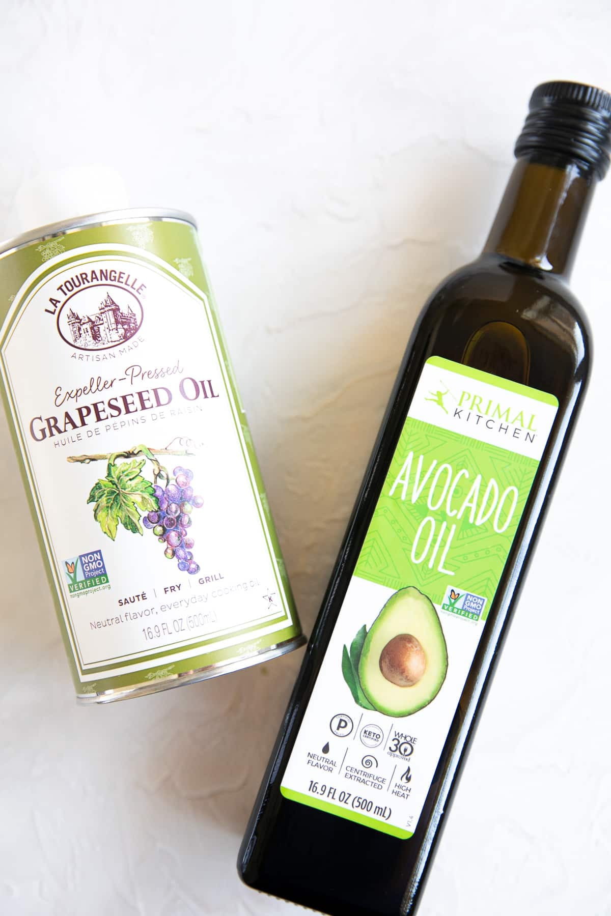 A bottle of grapeseed oil and a bottle of avocado oil