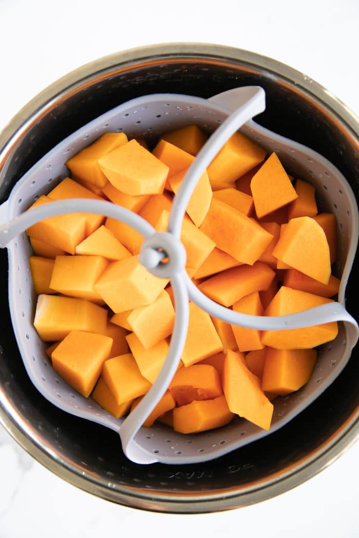 Cubes of butternut squash in a silicone basket in an Instant Pot.