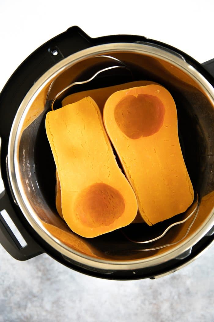 Fully cooked whole butternut squash halves cooling in an Instant Pot.