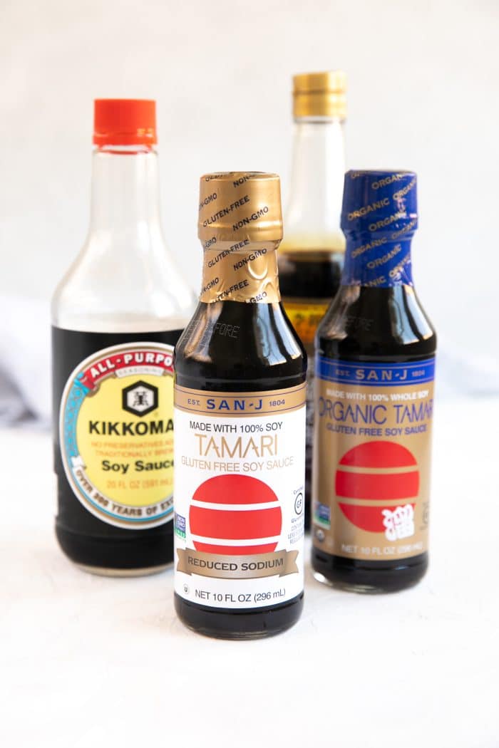 Bottles of soy sauce and tamari set on a table.