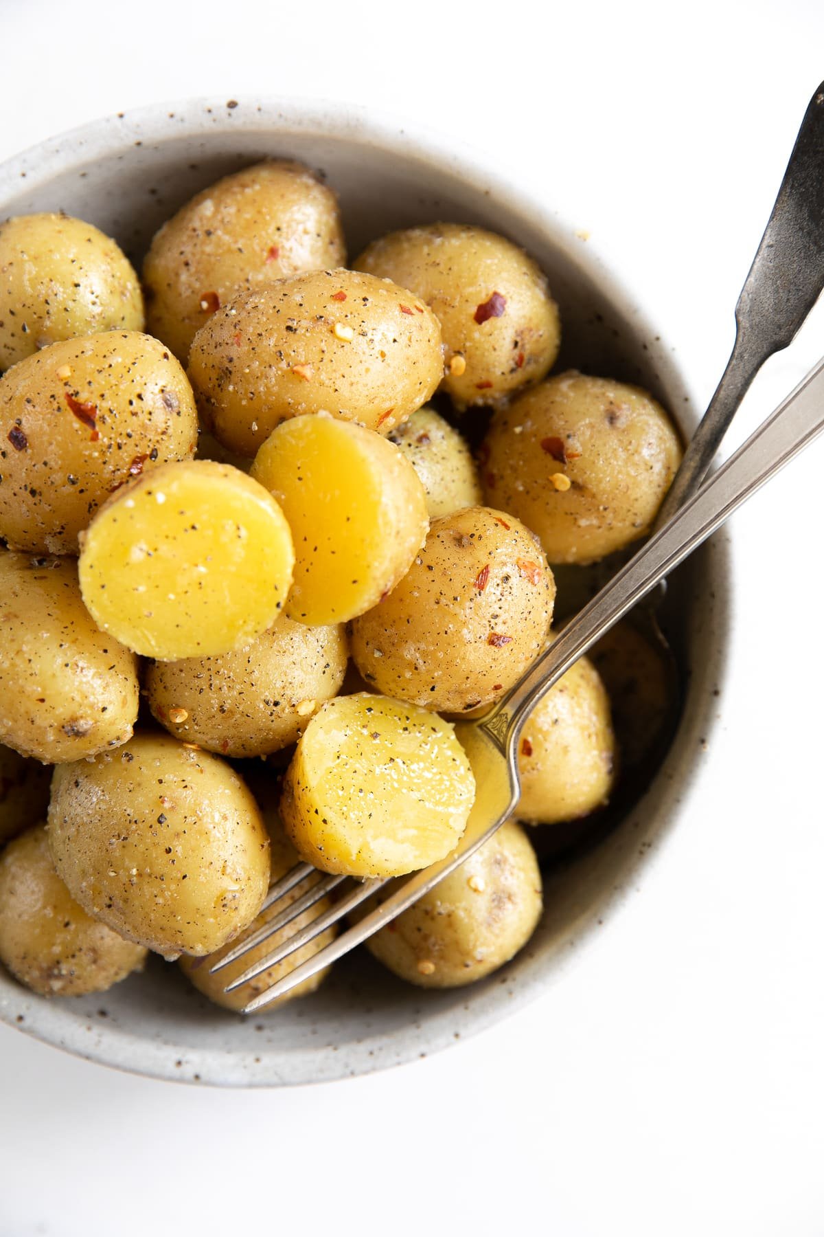 Round serving bowl filled with small yellow boiled potatoes.