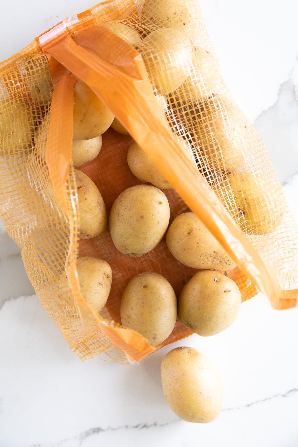 Bag filled with small mini yellow potatoes.