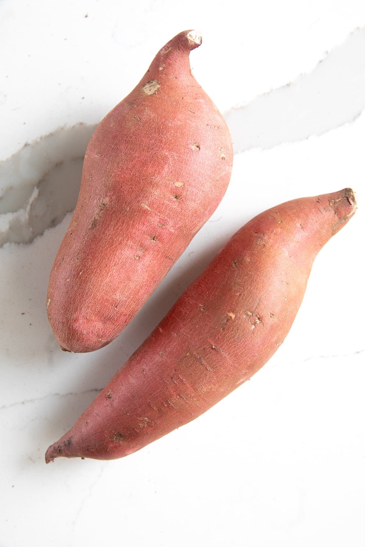 Two uncooked sweet potatoes.