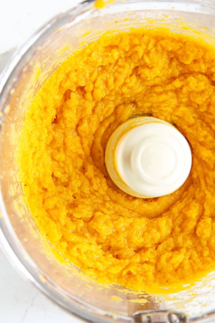 Food processor filled with freshly pureed pumpkin.