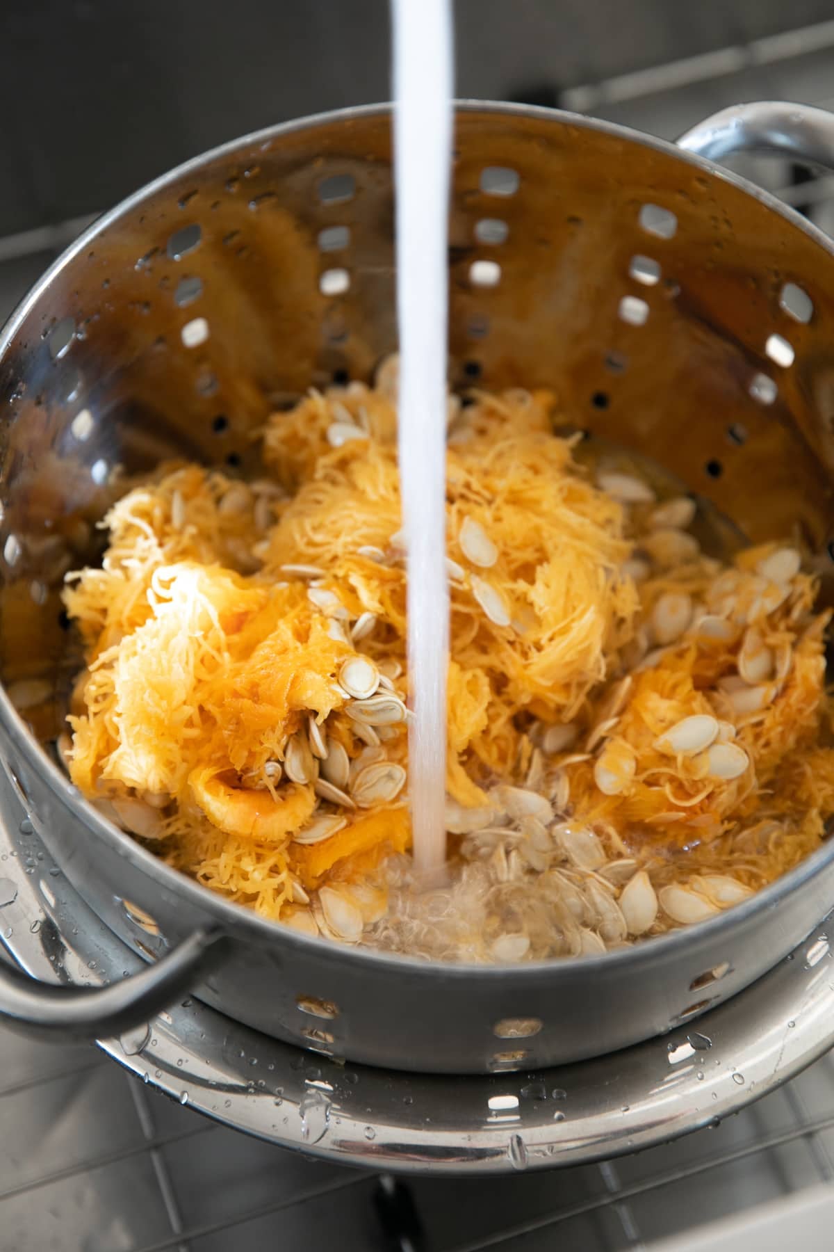 Rinsing and separating pumpkin seeds from stringy bits.