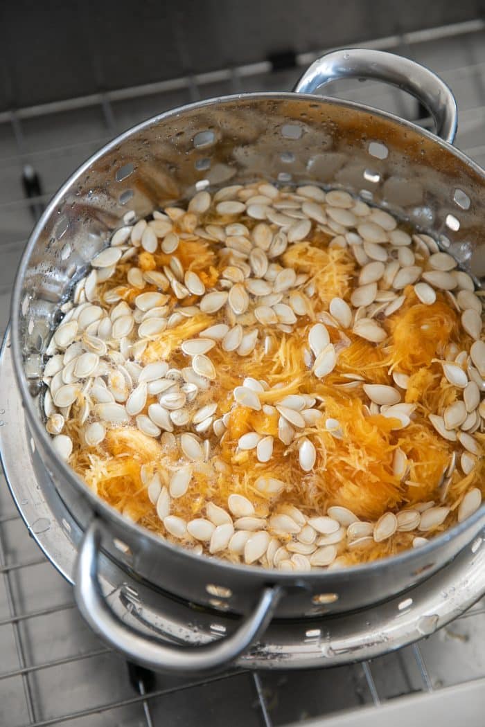 Separating pumpkin seeds from the stringy bits in a large colander