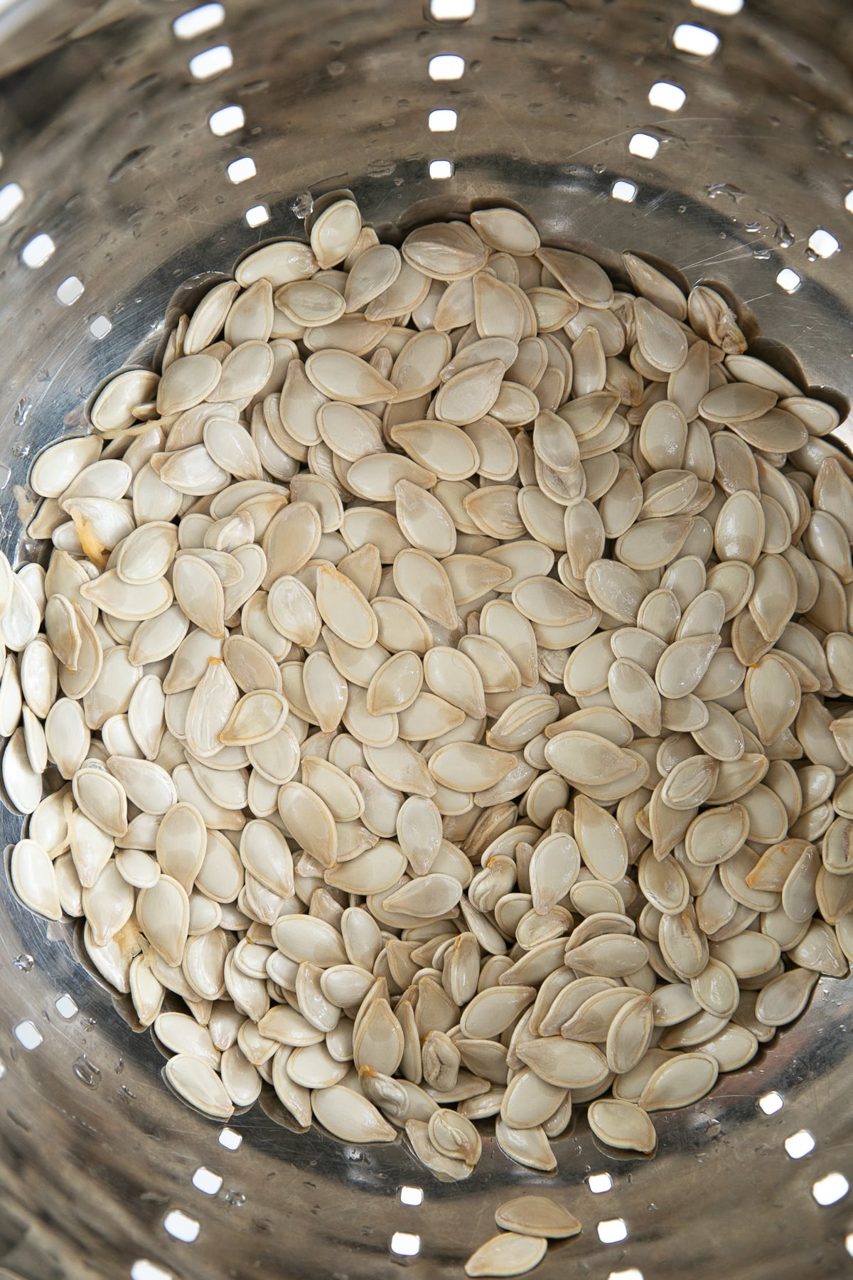 Raw pumpkin seeds in a colander