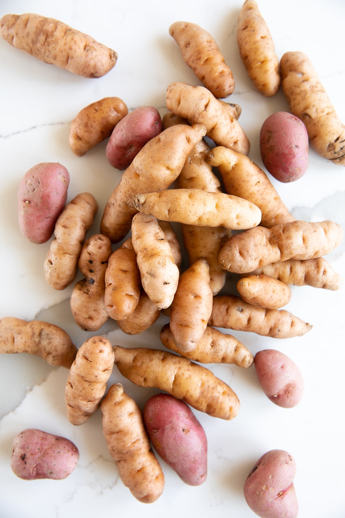 Mix of yellow and red raw fingerling potatoes.