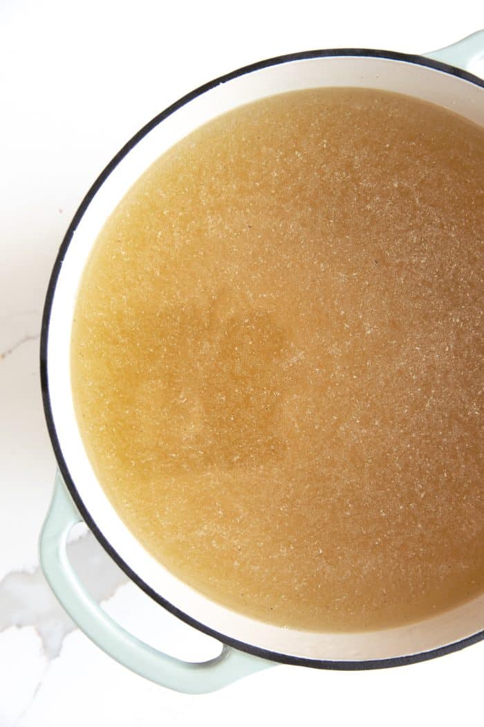Homemade strained turkey stock in a large Dutch oven.
