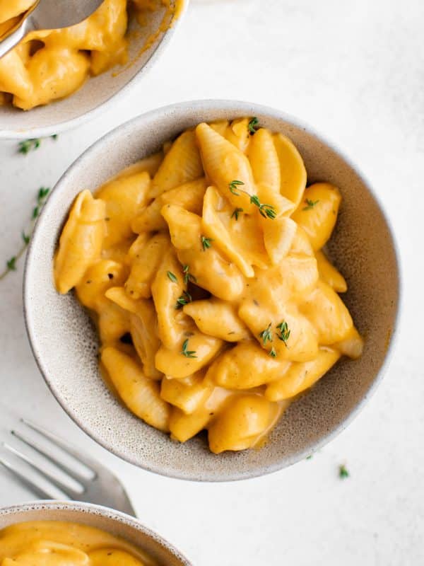 Overhead shot of three bowls of butternut squash mac and cheese with forks.